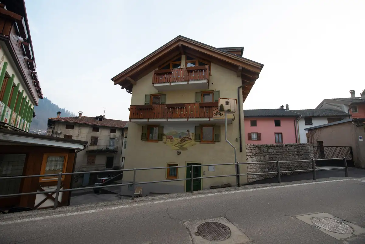 La casetta di fronte all'albergo, con balconi in legno e facciata dipinta