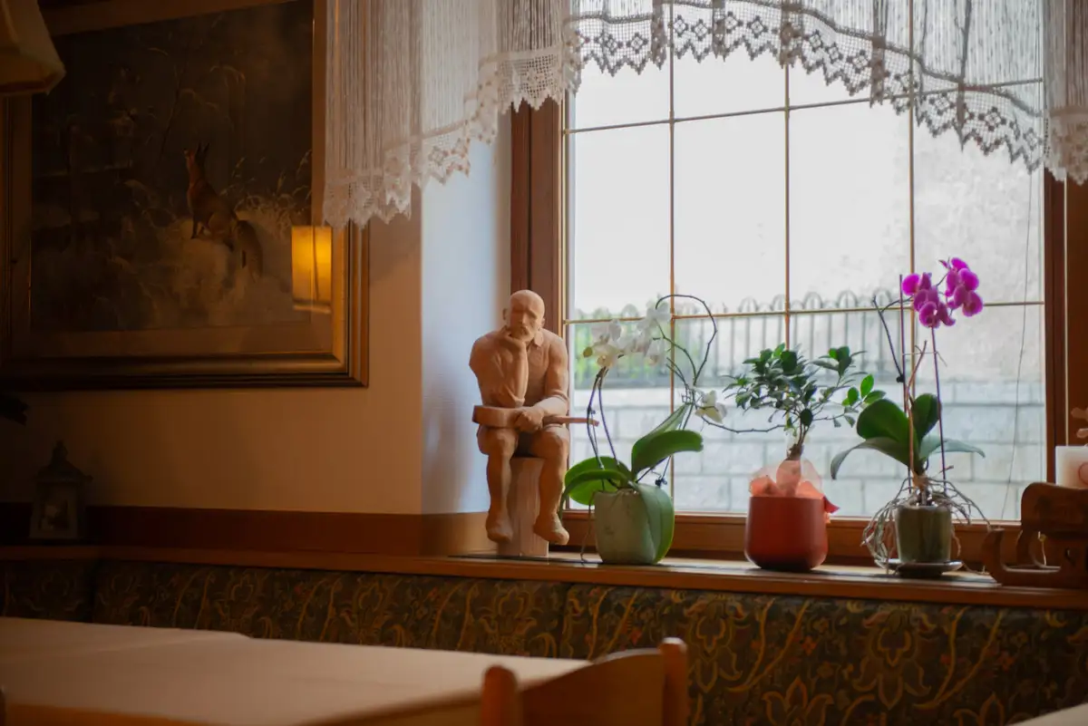 Davanzale con orchidee e una figura in legno intagliato