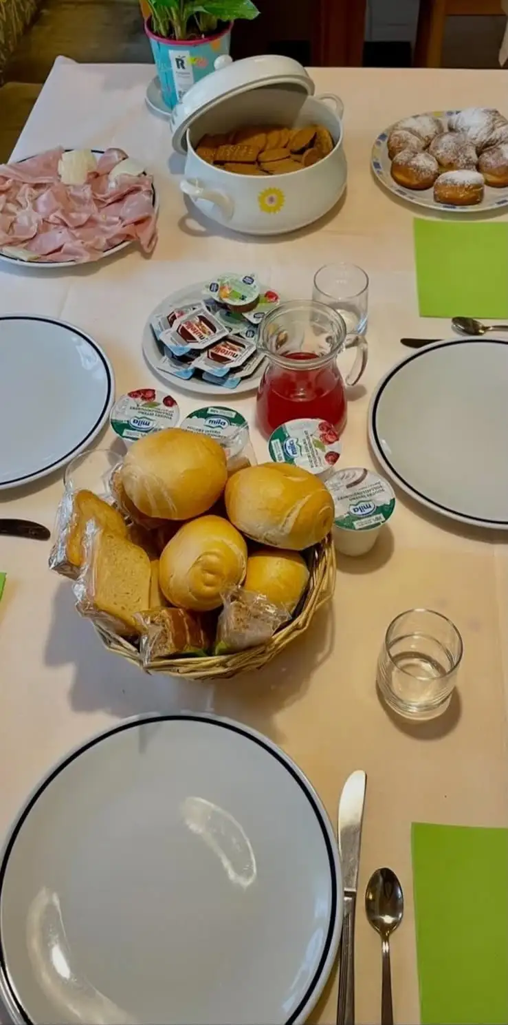 La tavola della colazione con pane, yogurt, biscotti, dolci e affettati