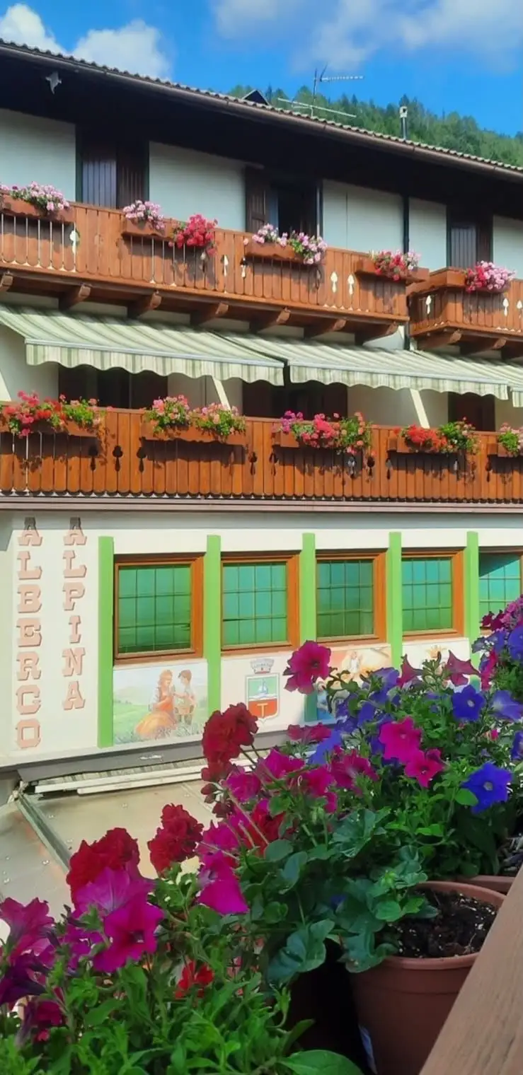 I balconi fioriti e la facciata dell’Albergo Alpina visti dalla dependance