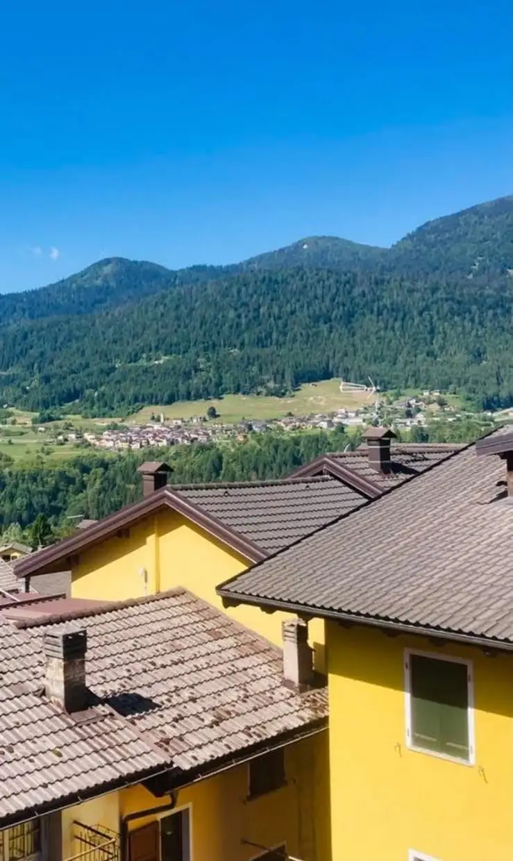 Le case e le montagne del Tesino in una giornata estiva