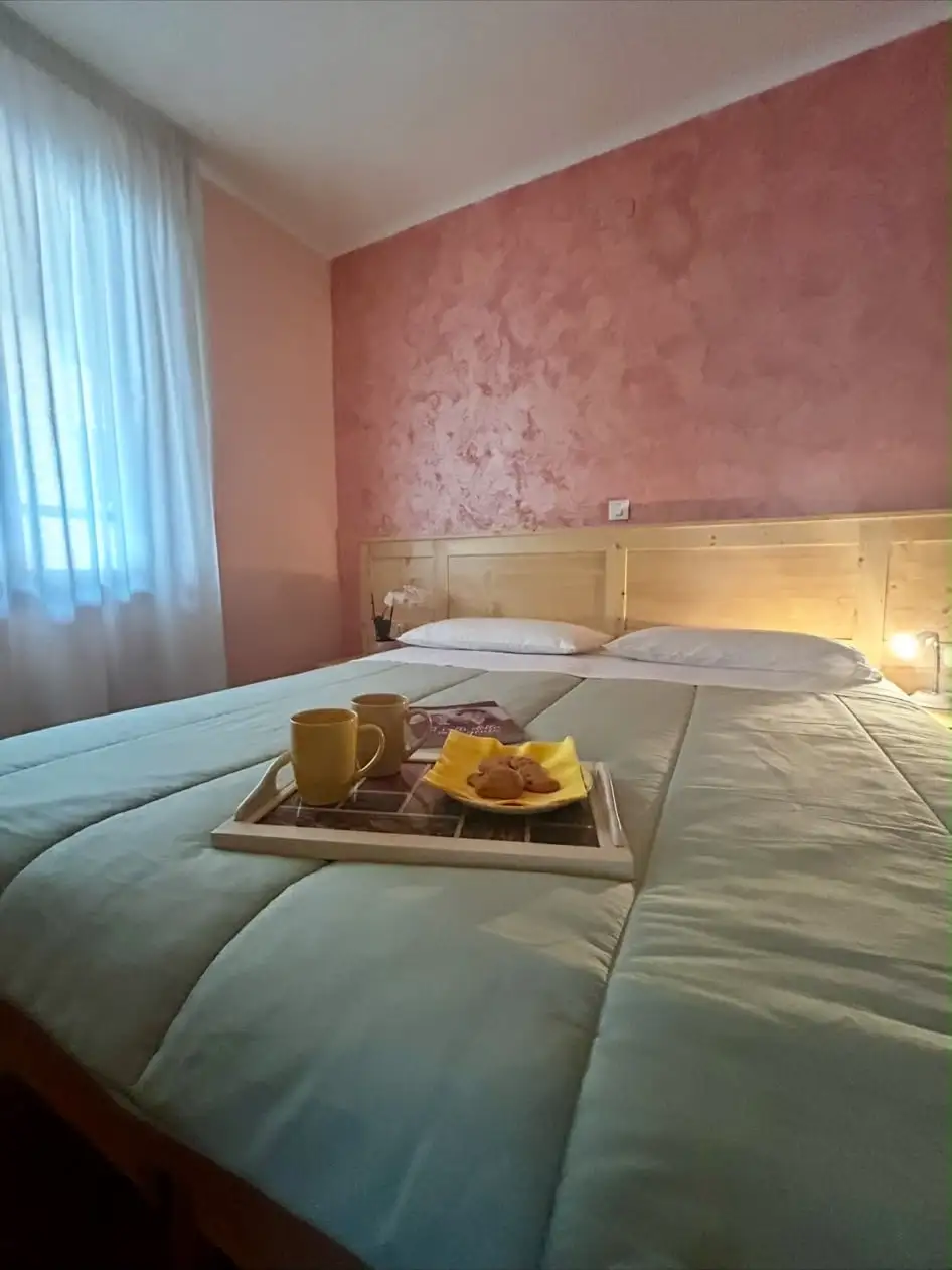 Il letto nella seconda camera della quadrupla comunicante, con parete rosa