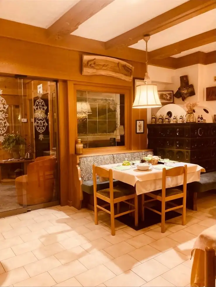 Un tavolo apparecchiato nella sala con stufa e arredi in legno